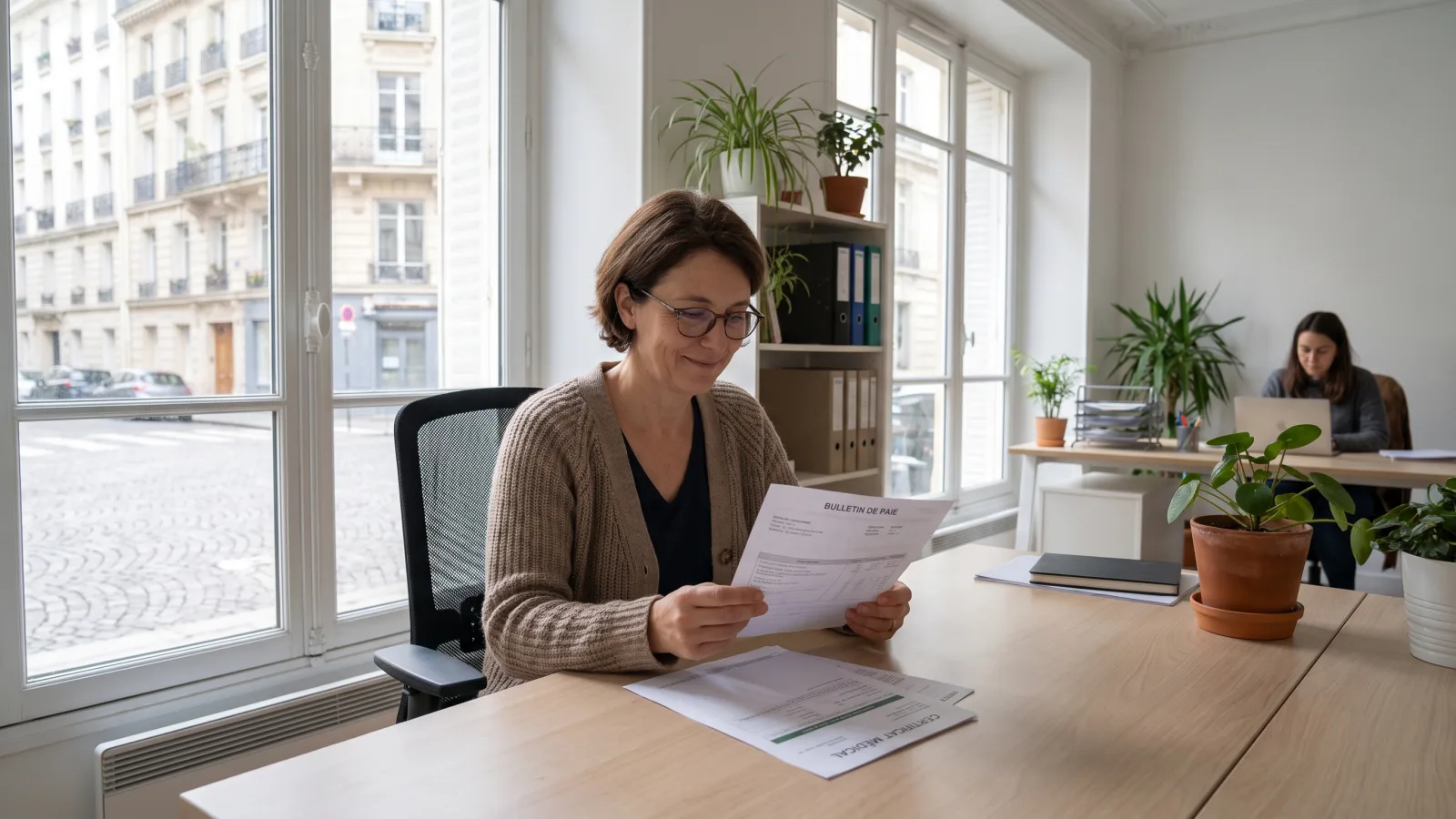 Salarié examinant son bulletin de paie et son arrêt maladie pour le maintien de salaire
